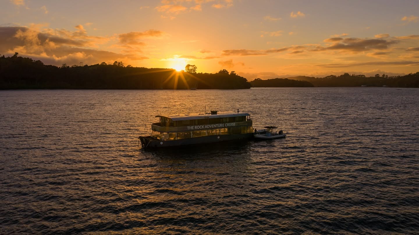 The Rock Adventure Cruise anchored in the Bay of Islands at golden sunset