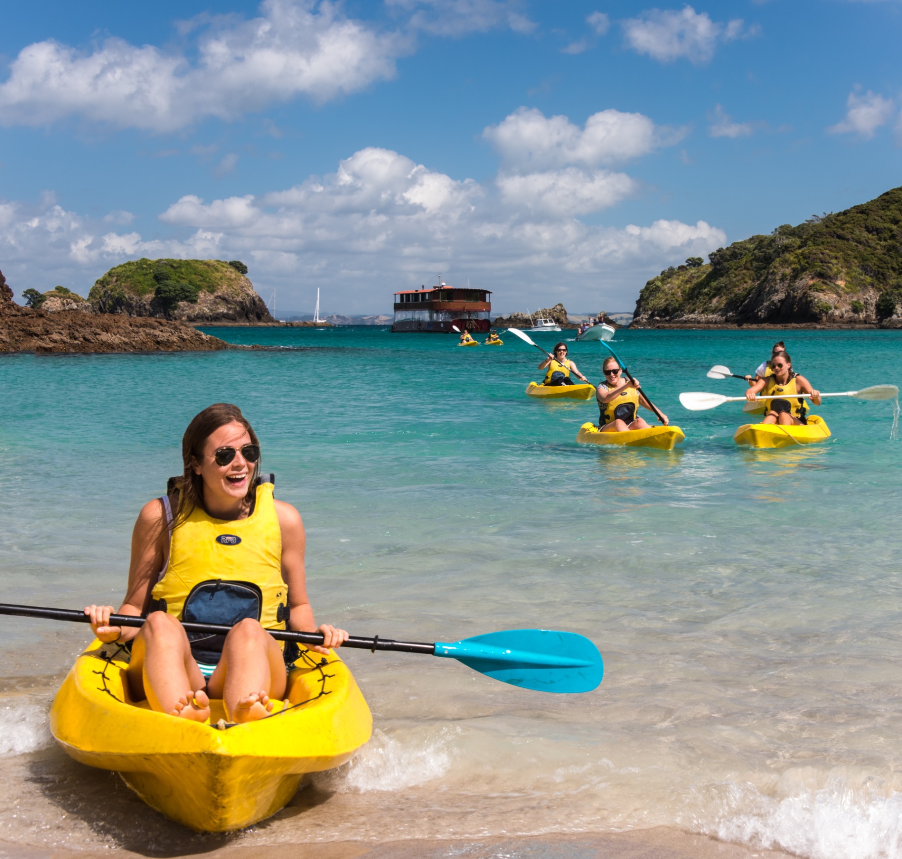 Family kayaking in crystal-clear water beside The Rock