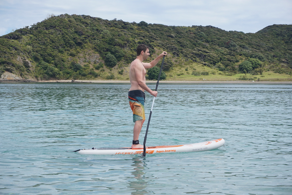 stand paddle boarding at the rock bay of islands