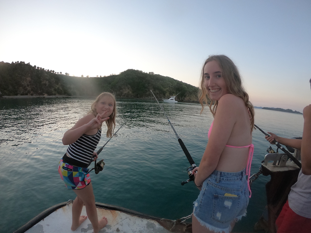 girls having fun while dusk fishing in the bay of islands
